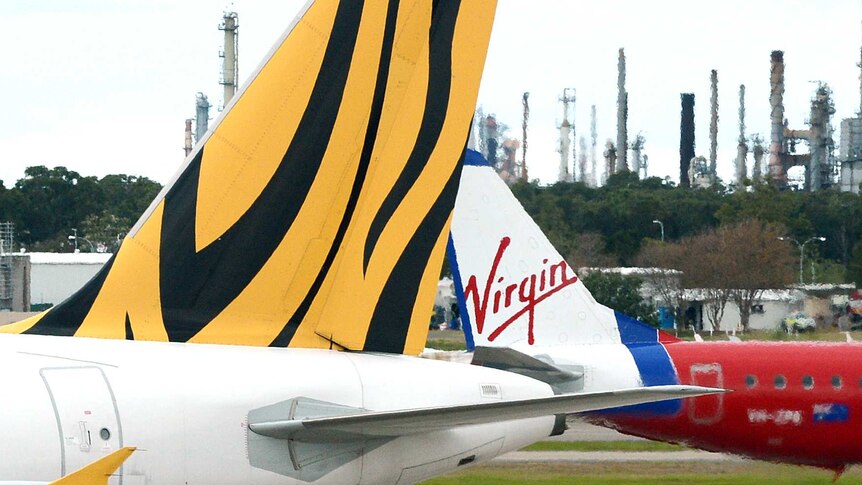 Virgin Australia and Tiger Airways planes pass each other.