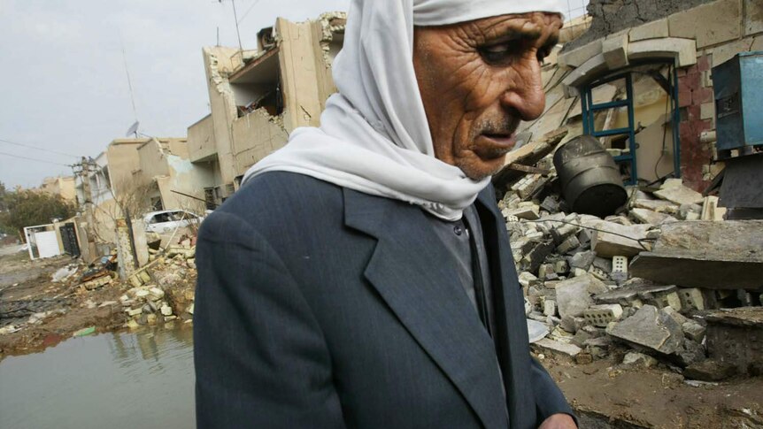 An Iraqi man turns away from the damage done to a restaurant in Baghdad