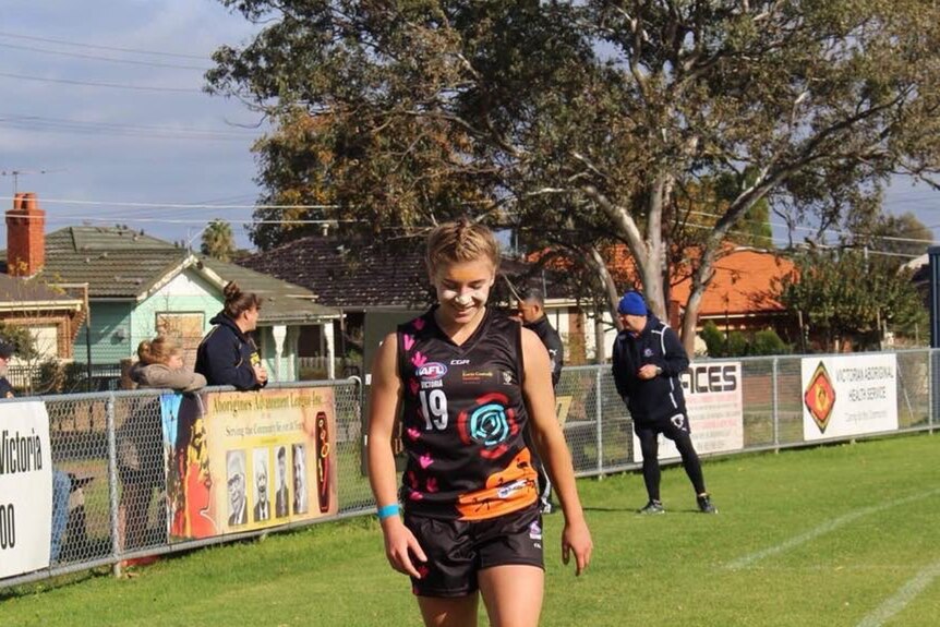 Marissa Williamson-Pohlman walking along a boundary line during an Aussie rules match