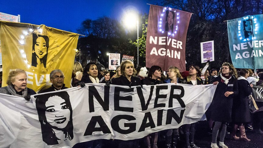 Irish pro-choice protesters turn out for a rally in Dublin, holding a sign with the face of Savita Halappanavar.