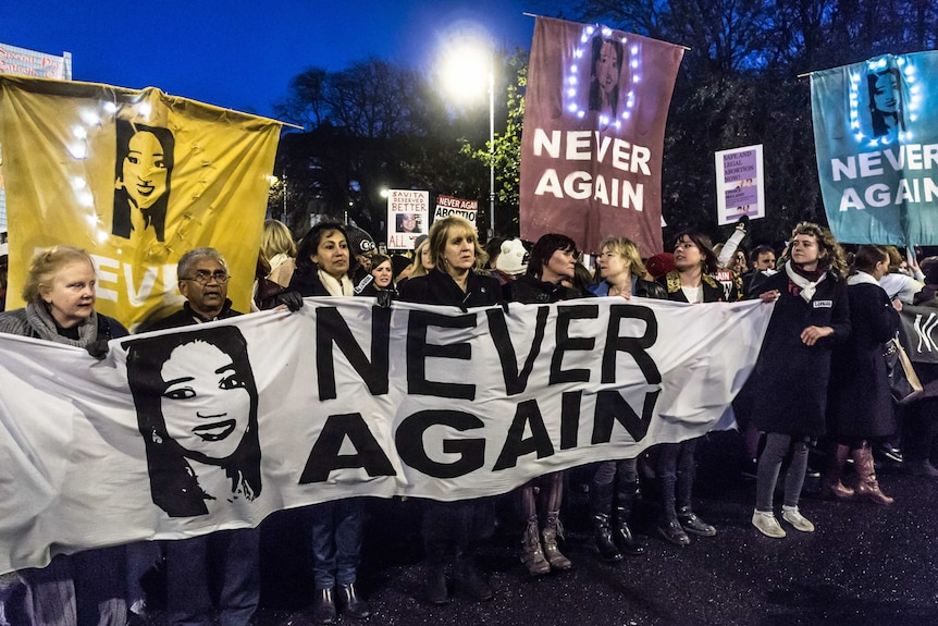 Irish pro-choice protesters turn out for a rally in Dublin, holding a sign with the face of Savita Halappanavar.