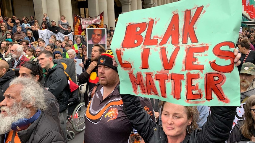 A 'Black Lives Matter' banner is held up at a protest rally in Melbourne's CBD.