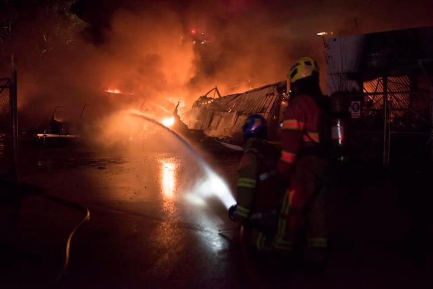 A firefighter uses a hose to fight the fire