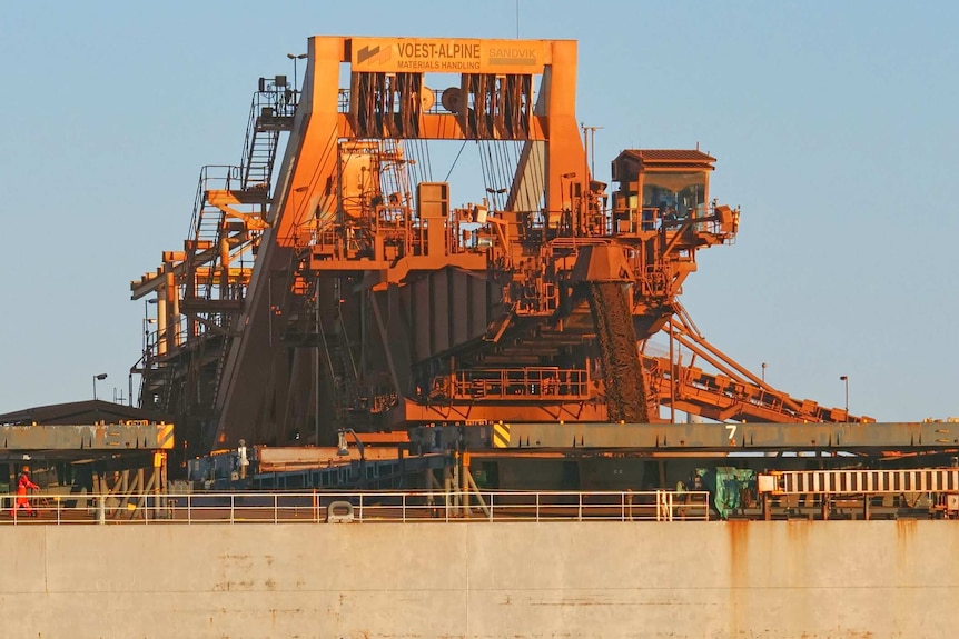 Iron ore is loaded into storage via a large conveyor belt.