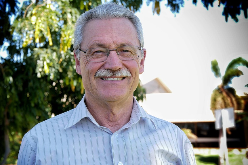 A head and shoulders shot of a smiling Karratha Mayor Peter Long outdoors.