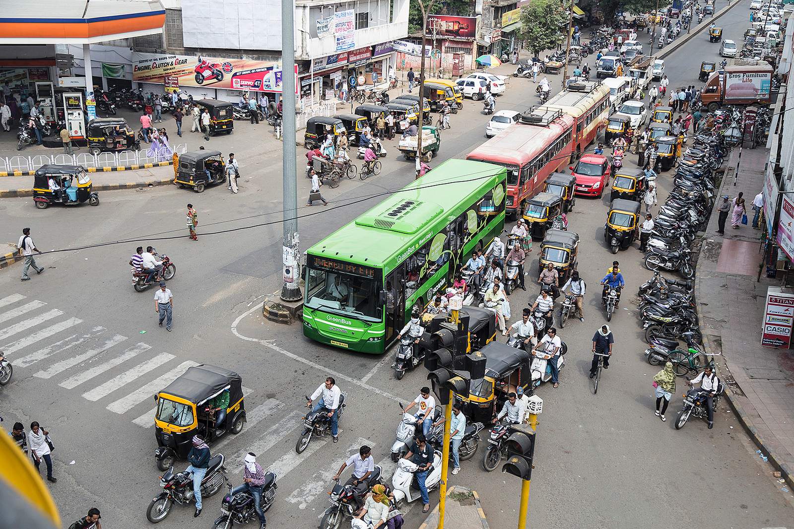 A street in India with buses, cars, and many people on motorbikes