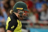 Australia batter Meg Lanning walks off the field with her head down after being dismissed.