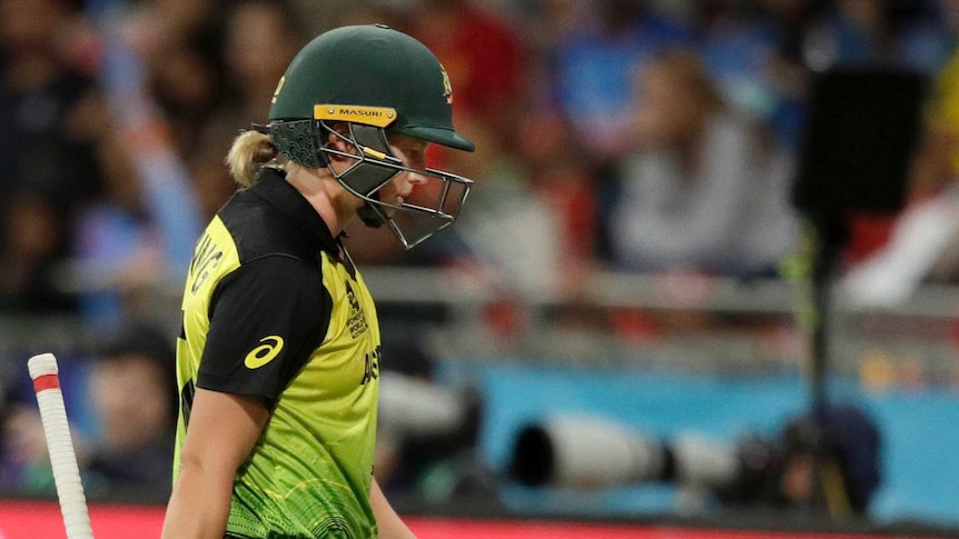 Australia batter Meg Lanning walks off the field with her head down after being dismissed.