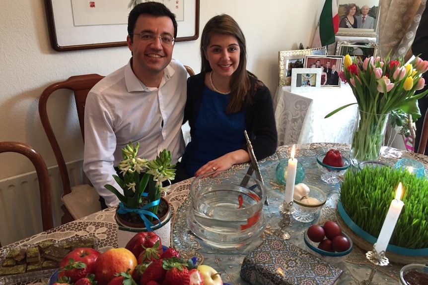 A couple at a table with items significant of Persian new year