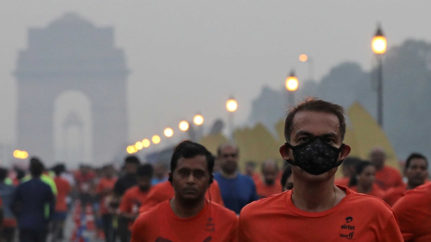 A number of people run through the streets of New Delhi during a marathon.