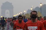 A number of people run through the streets of New Delhi during a marathon.