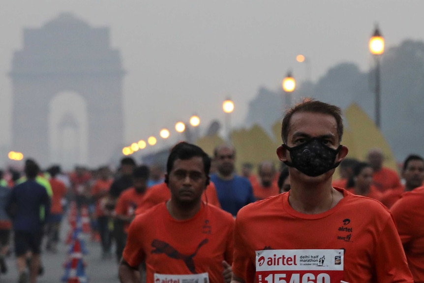 A number of people run through the streets of New Delhi during a marathon.