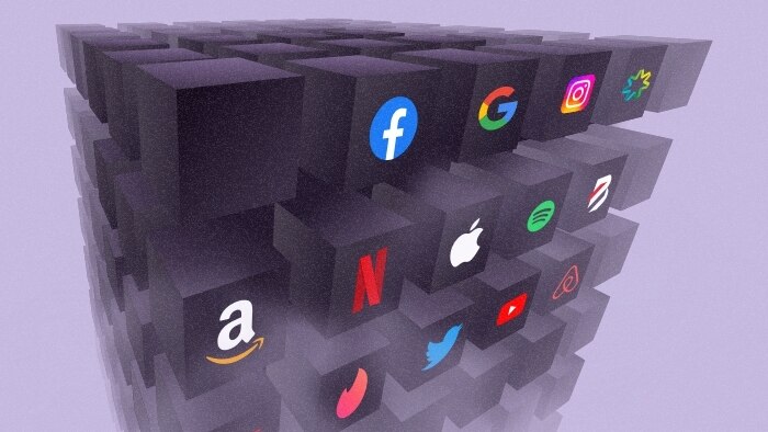 Many 3D black boxes with recognisable brand logos on them including Facebook, Netflix, Apple, and Twitter on a purple background