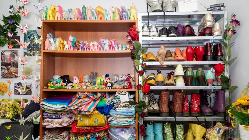 Two open wardrobes filled with coloured pony toys, folded clothes and colourful shoes.