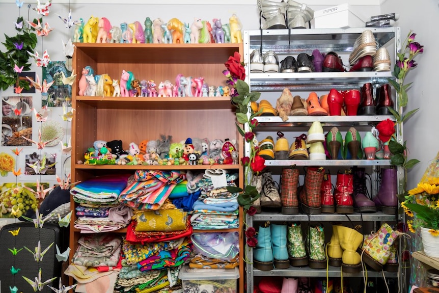 Two open wardrobes filled with coloured pony toys, folded clothes and colourful shoes.