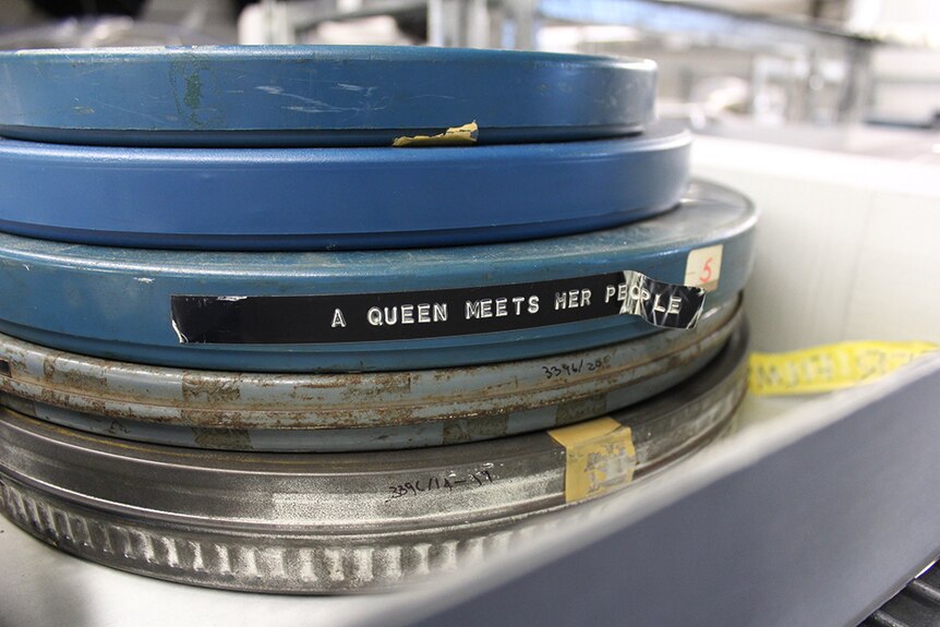 A stack of blue plastic film reel cases, one labelled "A Queen meets her people".