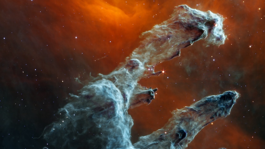 A highly detailed image of the Pillars of Creation, ghostly giant trails of blue-grey dust against an orangey-black background