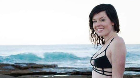 A young woman poses in a bikini.