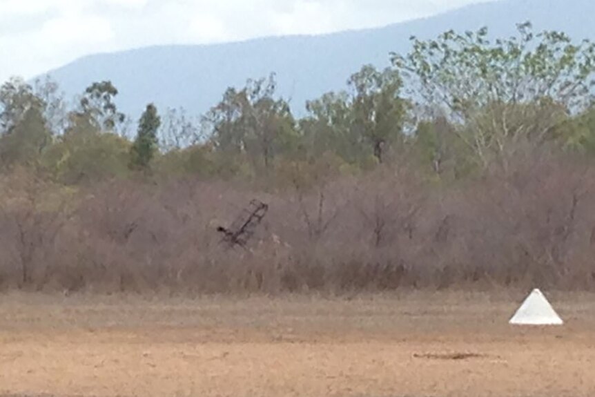 Charred remains of ultralight plan in scrubland near an airfield runway