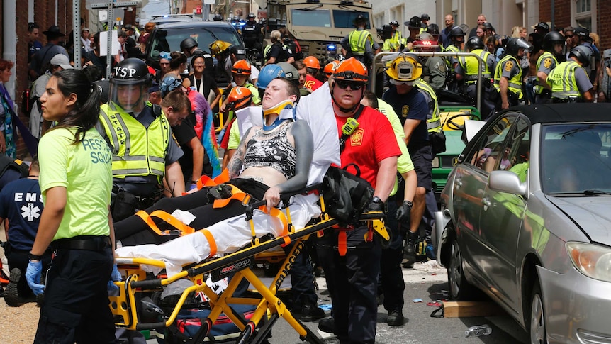 A woman is carried away on a stretcher as authorities attend to people.