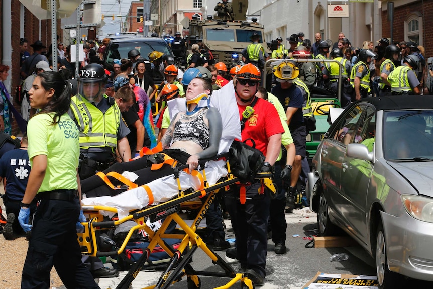 A woman is carried away on a stretcher as authorities attend to people.