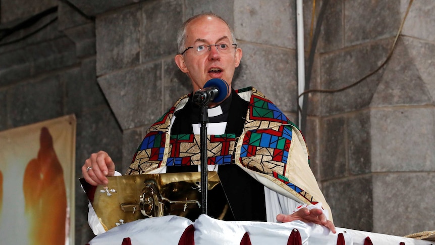 A senior clergyman in full regalia holds forth from a pulpit.