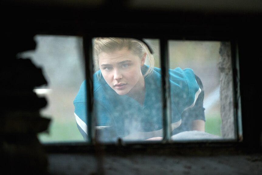 Chloë Grace Moretz looks through a grimey window in film The Miseducation of Cameron Post.