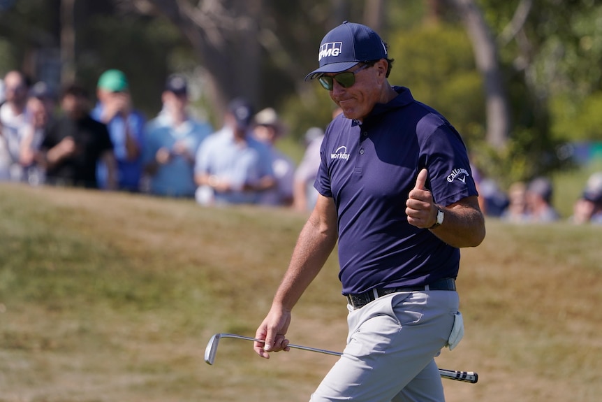 Phil Mickelson walks with his thumb up