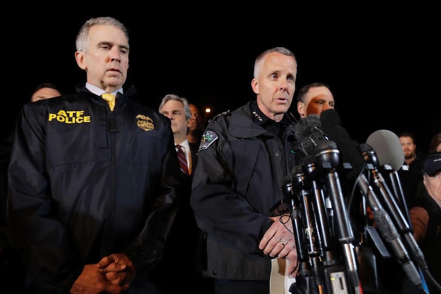 Austin police chief Brian Manley speaks to media while surrounded by other law enforcement officers.