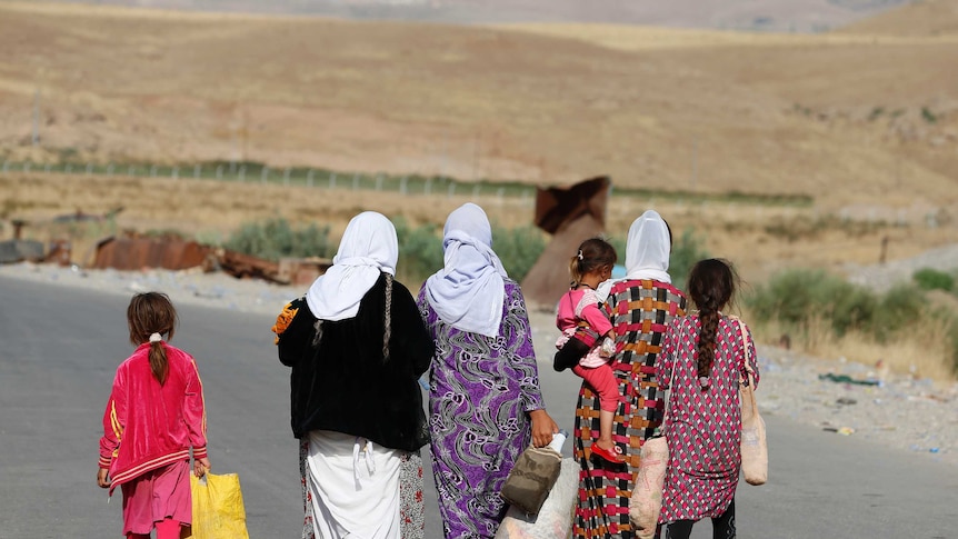 Yazidi women and children flee violence in Iraq.