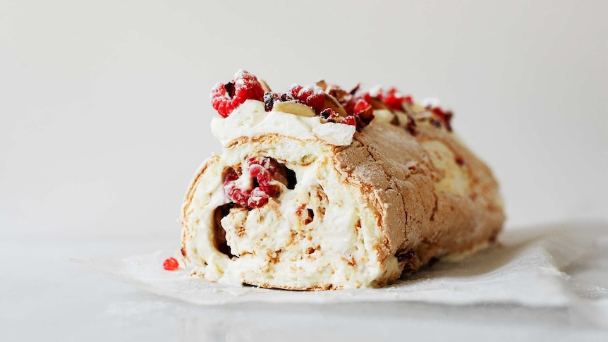 Pavlova roll with mascarpone cream and raspberries inside with a cream and raspberry topping, a delicious summer dessert recipe.
