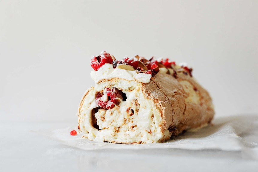 Pavlova roll with mascarpone cream and raspberries inside with a cream and raspberry topping, a delicious summer dessert recipe.