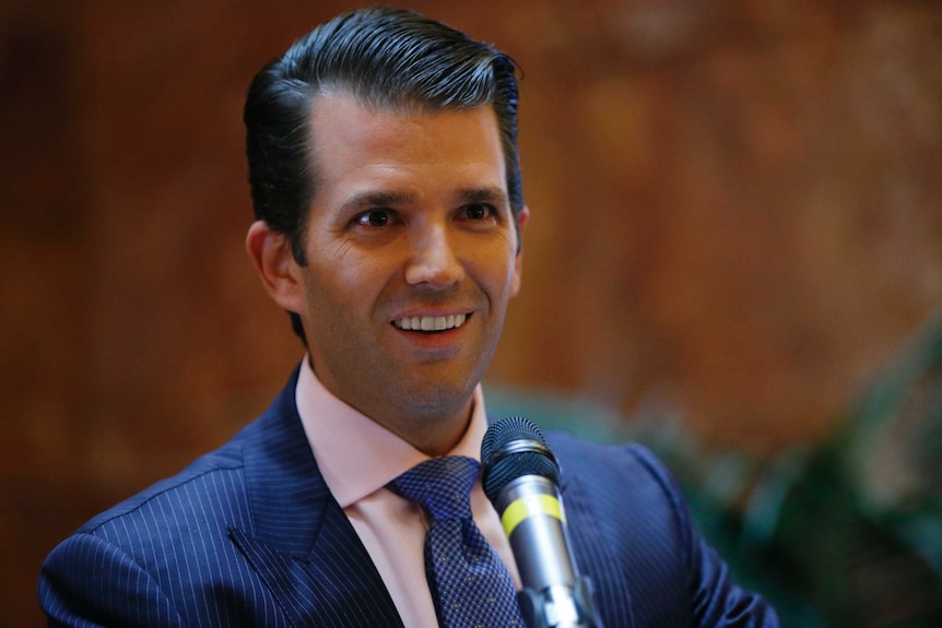Donald Trump Jr flashes a coy smile at a press conference announcing the launch of a new hotel chain