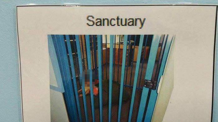 A sign placed on the wall of the classroom of a child with autism, showing the child inside a cage with the label sanctuary.