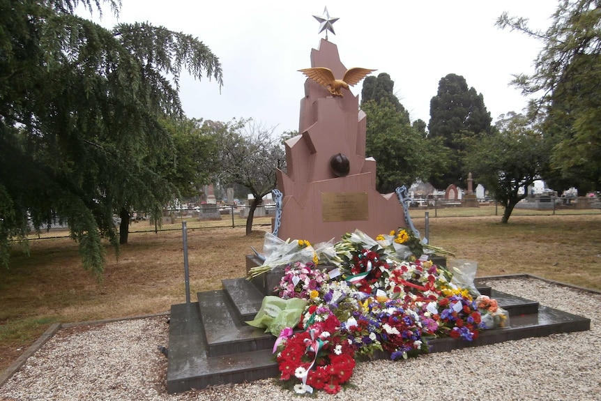 monument with lots of flowers at its base