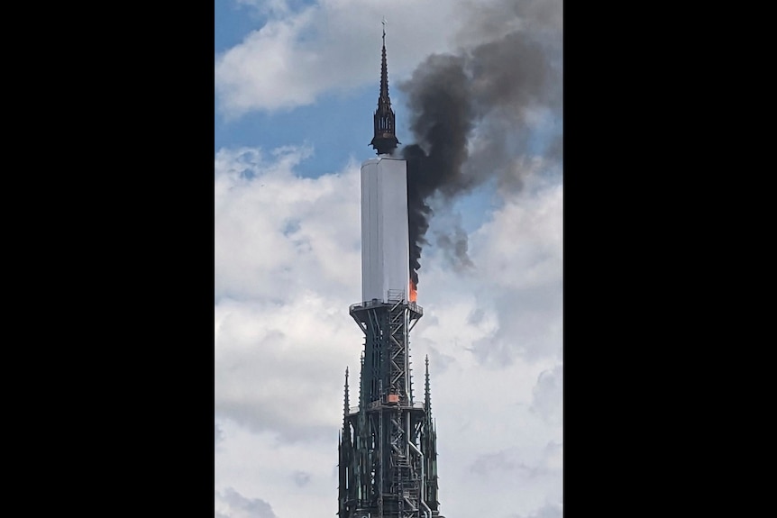 The spire of a cathedral on fire 