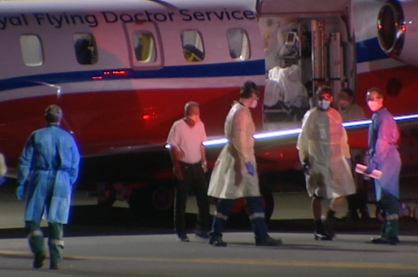 Medical staff surround a Royal Flying Doctor Service plan which flew the man home to Perth.