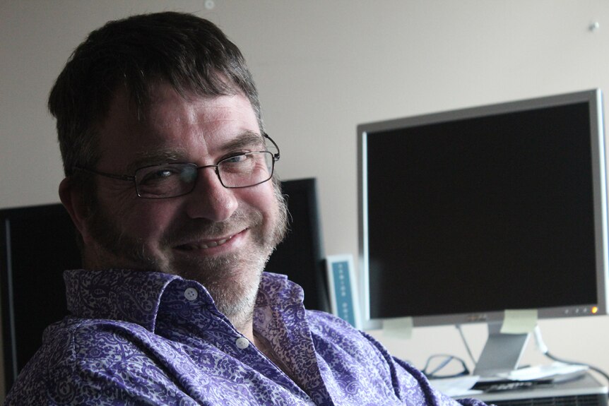 Portrait of man with glasses smiling.