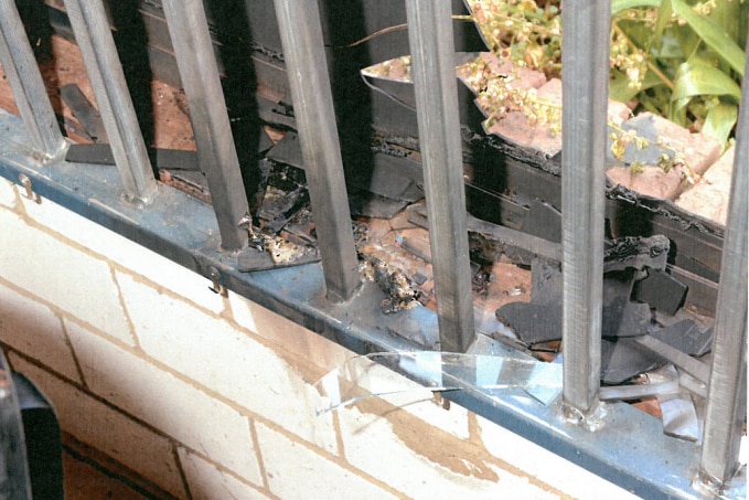 Close up of bars over a window with some fire damage