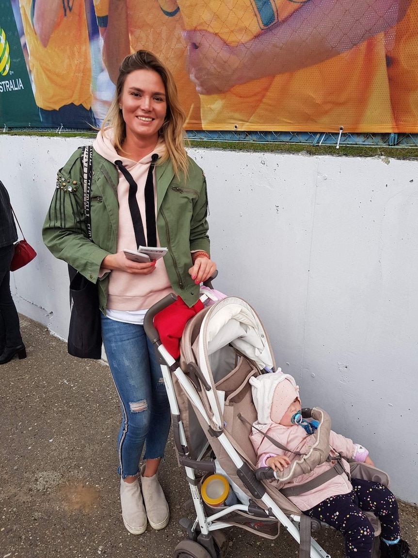 Kazan resident with baby near Socceroos wall