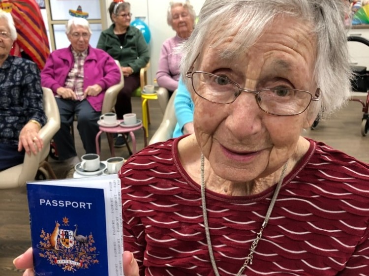 A lady holds her special passport that's been made for the arm chair travel program at an aged care home