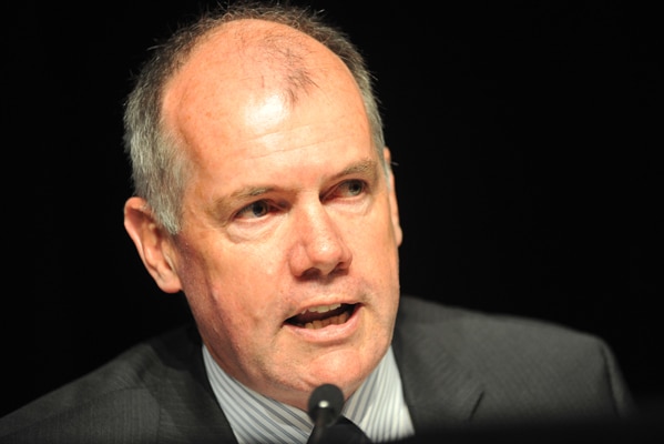 Close up of man in suit speaking into a microphone