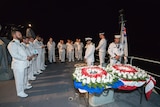 Sailors aboard ship take part in a ceremony commemorating the HMAS Perth.