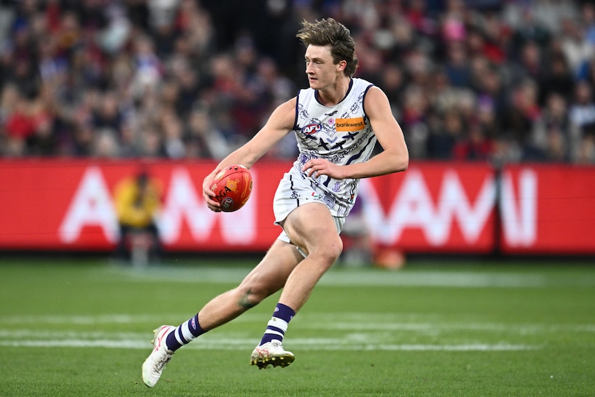 Fremantle Dockers player Jye Amiss carries the ball during a game. 