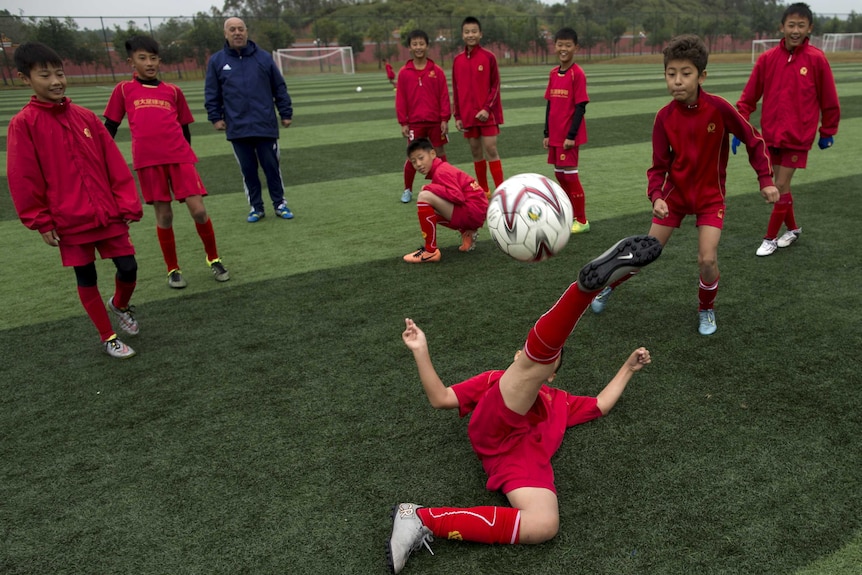A group of Chinese children play soccer on the field.