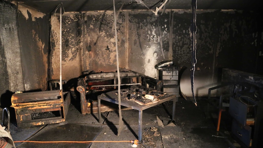 The blackened and burned remains of furniture including a sofa and table in a mock apartment.