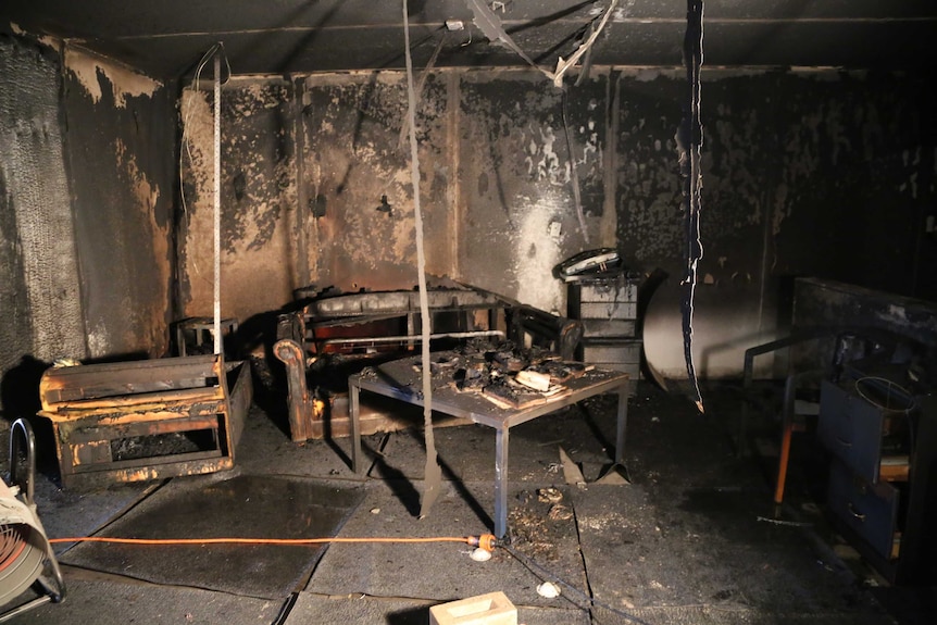 The blackened and burned remains of furniture including a sofa and table in a mock apartment.