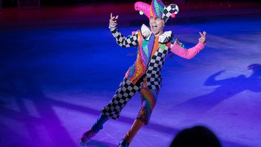 Ice skater Roman Khitiaev performing on ice dressed in a jester costume
