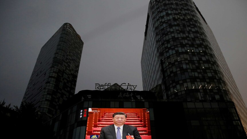 Screen shows news footage of Chinese President Xi Jinping at the closing session of NPC in Beijing.