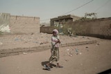A girl walks alone on a street in al-Khoukha, Yemen.